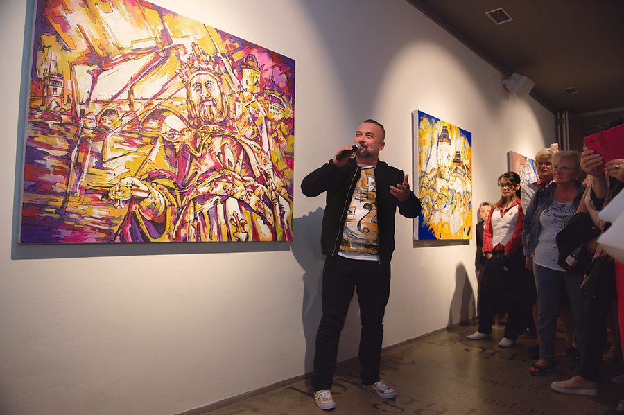 Joe Muczka jr. erklärt ein Werk vor Gästen in einer Galerie